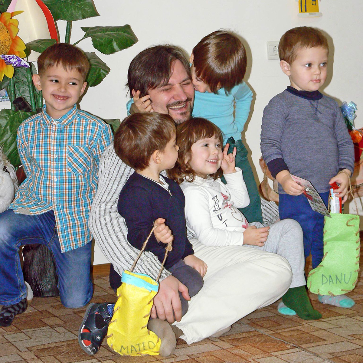 Educatorul îmbrățișat de copii